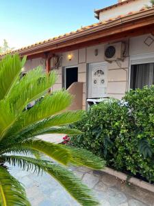 una casa con una palma di fronte di villa panorama a Asprovalta