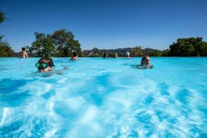 um grupo de pessoas a nadar numa piscina em Charmant camping Familiale 3 Etoiles vue 360 plage piscine à débordement empl XXL em Labeaume