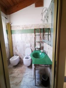 bagno con lavandino verde e servizi igienici di Casamare Hotel a San Vincenzo