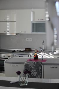 a kitchen with white cabinets and a counter with a table at Chic apartment in the City Center by the sea in Tivat