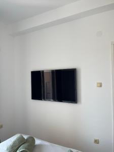 einen Flachbild-TV, der an einer weißen Wand hängt in der Unterkunft Apartmani Miliša in Primošten