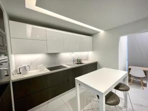 a kitchen with white cabinets and a white table at Luxury Apartment in Nicosia By Platform 357 in Nicosia