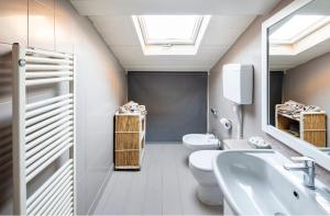 a bathroom with a white toilet and a sink at HOUSE Cavour 24 In the heart of Downtown Parma in Parma +14 photos