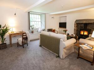 a living room with a couch and a fireplace at Little How in Ambleside