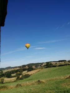 un globo de aire caliente volando sobre un campo verde en Chambre campagne uxelloise, en Uxeau