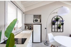 a kitchen with white cabinets and a refrigerator at HOUSE Cavour 24 In the heart of Downtown Parma in Parma