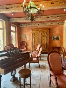 a dining room with a piano and chairs at Hôtel Du Théâtre Centre Historique - Parking Souterrain Public Gratuit in Metz