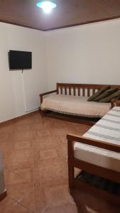 a room with two beds and a flat screen tv at ALOJAMIENTO FAMILIAR in Puerto Iguazú