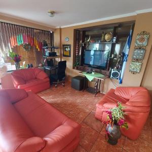 a living room with red couches and a flat screen tv at Hotel Torre Fuerte in Venecia
