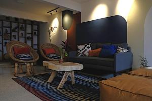 a living room with a blue couch and two chairs at Casa Crónica in Oaxaca City