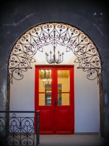 un arco con una porta rossa e un lampadario a braccio di Nur Guest House a Gyumri