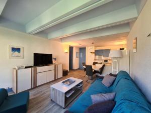 een woonkamer met een blauwe bank en een tafel bij Appartement Flaine, 2 pièces, 6 personnes - FR-1-425-47 in Flaine