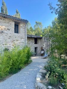 un bâtiment en pierre avec un banc devant lui dans l'établissement La Source, à Rustrel