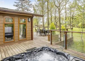 eine große Holzterrasse mit einem Tisch und Stühlen darauf in der Unterkunft Ladera Retreat Lodges in Eaton