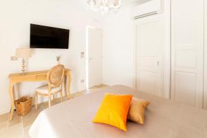 a bedroom with a bed with a yellow pillow and a desk at La Posta del Guardiano in Vieste