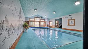 a swimming pool in a house with a painting on the wall at Yellowstone Village Inn and Suites in Gardiner