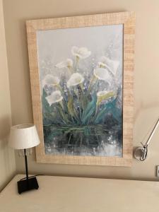 a painting of white flowers on a wall next to a lamp at Petit Rosselló in Barcelona