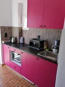 a kitchen with pink cabinets and a sink at Countryside Retreat 2 in Agios Arsenios +19 photos