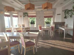 a dining room with tables and chairs and windows at Sapsan in Ternopil