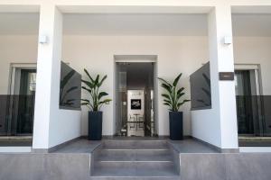 a hallway with two potted plants in a building at Moonlight B&B in Porto Cesareo