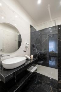 ein Badezimmer mit einem weißen Waschbecken und einem Spiegel in der Unterkunft Moonlight B&B in Porto Cesareo