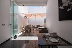 a dining room with a table and chairs and an umbrella at Moonlight B&B in Porto Cesareo