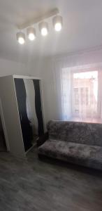 a living room with a couch and a window at Apartament Po schodkach in Duszniki Zdrój