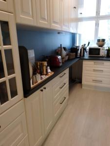 a kitchen with white cabinets and a counter top at 4 bedroom flat in the heart of Oslo in Oslo