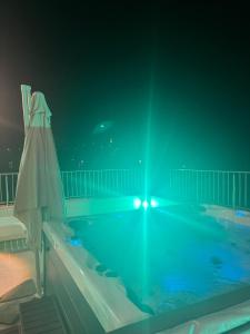 a large swimming pool at night with a umbrella at Casa 5ive in Tăşnad