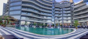 a swimming pool in front of a large building at Aparthotel Happy in Primorsko