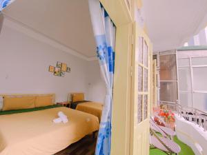 een kleine slaapkamer met een bed en een raam bij Happy House Homestay in Hue