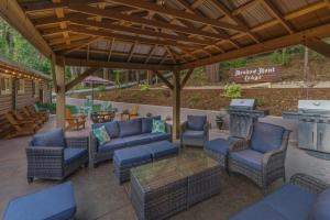 a patio with wicker chairs and a grill with a grill at Arnold Meadowmont Lodge in Arnold