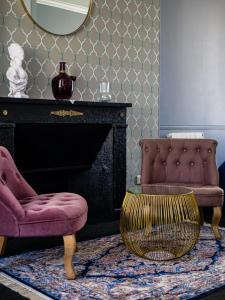 a living room with two chairs and a mirror at Le Clos de la Chapelle Bayeux in Bayeux