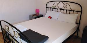 um quarto com uma cama preta e branca e um candeeiro rosa em Ομορφο διαμερισμα με μεγαλες βεραντες em Atenas