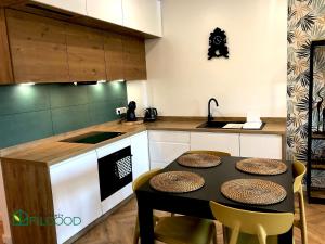 a kitchen with a table with chairs and a counter at Apartamenty FilGood in Wałcz