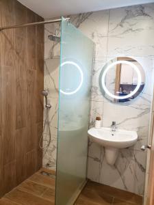 uma casa de banho com um lavatório e um espelho em KLEPALSKI - Mountain Studio em Borovets
