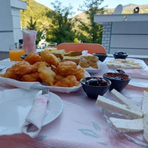 una mesa cubierta con platos de comida en una mesa en The White Villa en Poliçan