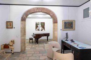 Habitación con piano y escritorio con ordenador. en B&B Cantiere dell'anima - Rooms of art, en Trapani