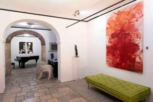 a living room with a green bench and a piano at B&B Cantiere dell'anima - Rooms of art in Trapani