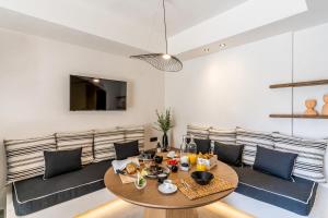 a dining room with a table and a couch at Amer Suites in Fira