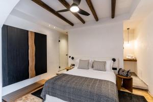 a bedroom with a large bed and a black wall at Amer Suites in Fira