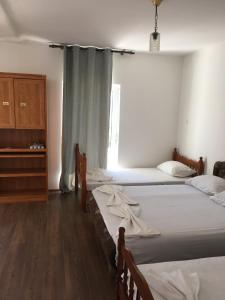 a bedroom with two beds and a dresser and a window at Vila Syhana in Ulcinj