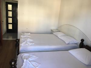 two beds in a room with white sheets and pillows at Vila Syhana in Ulcinj
