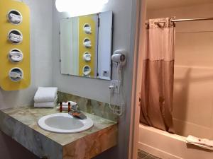 y baño con lavabo y ducha. en Travelodge Inn & Suites by Wyndham Missoula University Park en Missoula