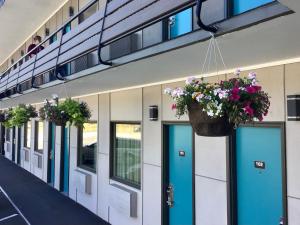 una fila de puertas con flores colgando de ellas en Travelodge Inn & Suites by Wyndham Missoula University Park, en Missoula