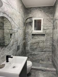 a bathroom with a sink and a toilet and a mirror at ID apartments in Tivat