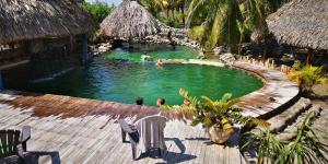 a pool at a resort with people swimming in it at Eco-Hotel Playa Quilombo in Las Lisas