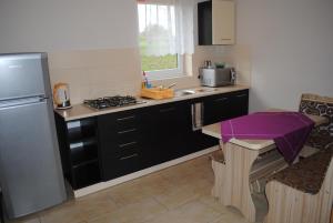 a kitchen with a sink and a stove top oven at Domki Nad Jeziorem 781-281-434 in Polańczyk