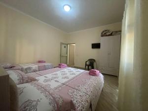 1 dormitorio con 2 camas con sábanas rosas y blancas en Vila Leo, en Golem