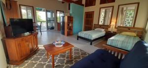 a living room with a couch and a tv at Belize Bay Estate in Punta Gorda